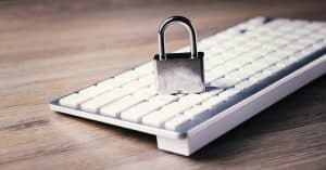 An image of a computer keyboard with a metallic padlock placed on it, symbolizing cybersecurity, data protection, and secure digital communication, emphasizing importance of security in technology.