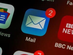 Smartphone screen showing email app with two unread messages, highlighting email security and scam prevention for businesses.